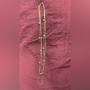 Gold necklace. Four attached strands, one with gold beads.